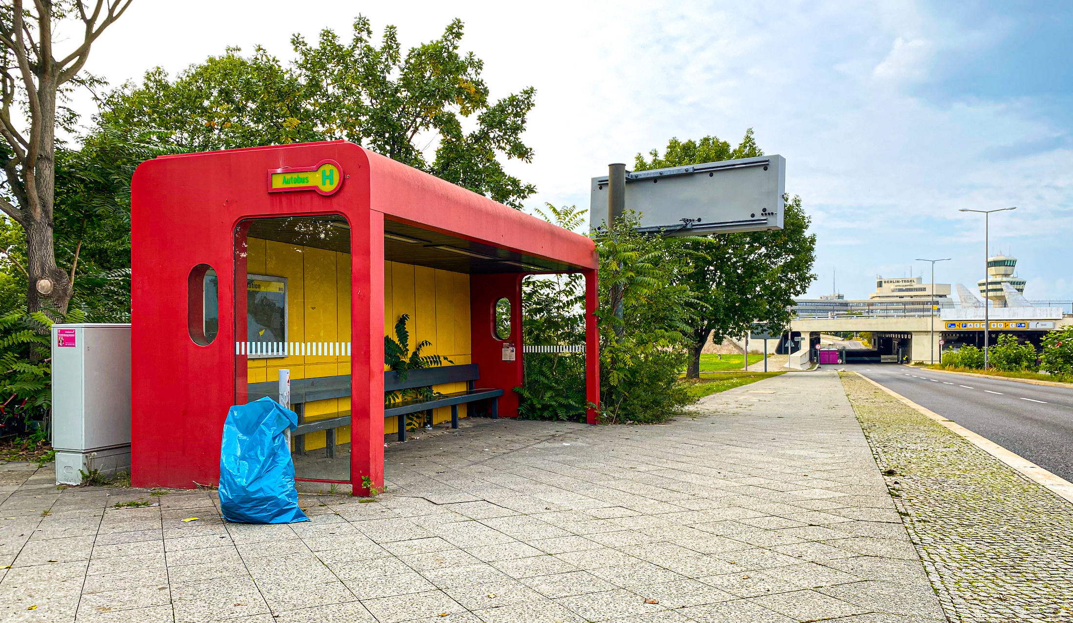 Bushaltestelle mit Flughafen im Hintergrund