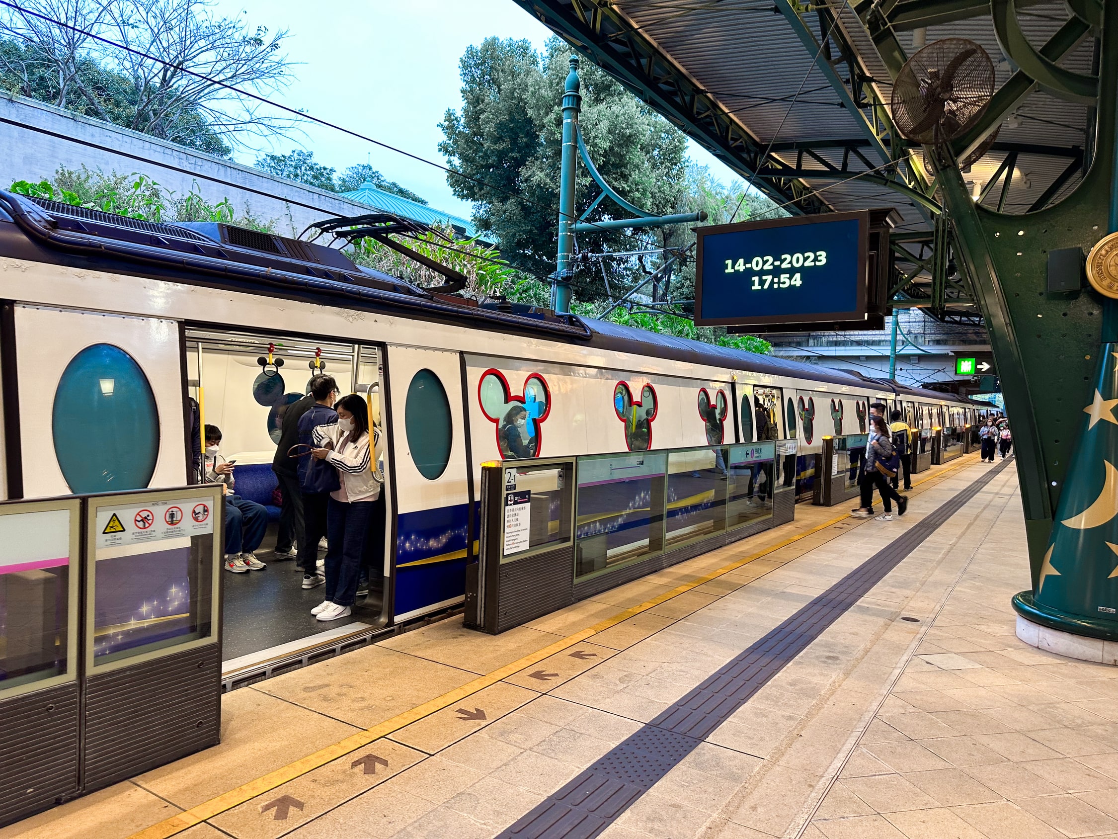 Ein Zug mit Fenstern in Form von Mickymäusen steht an einem Bahnsteig