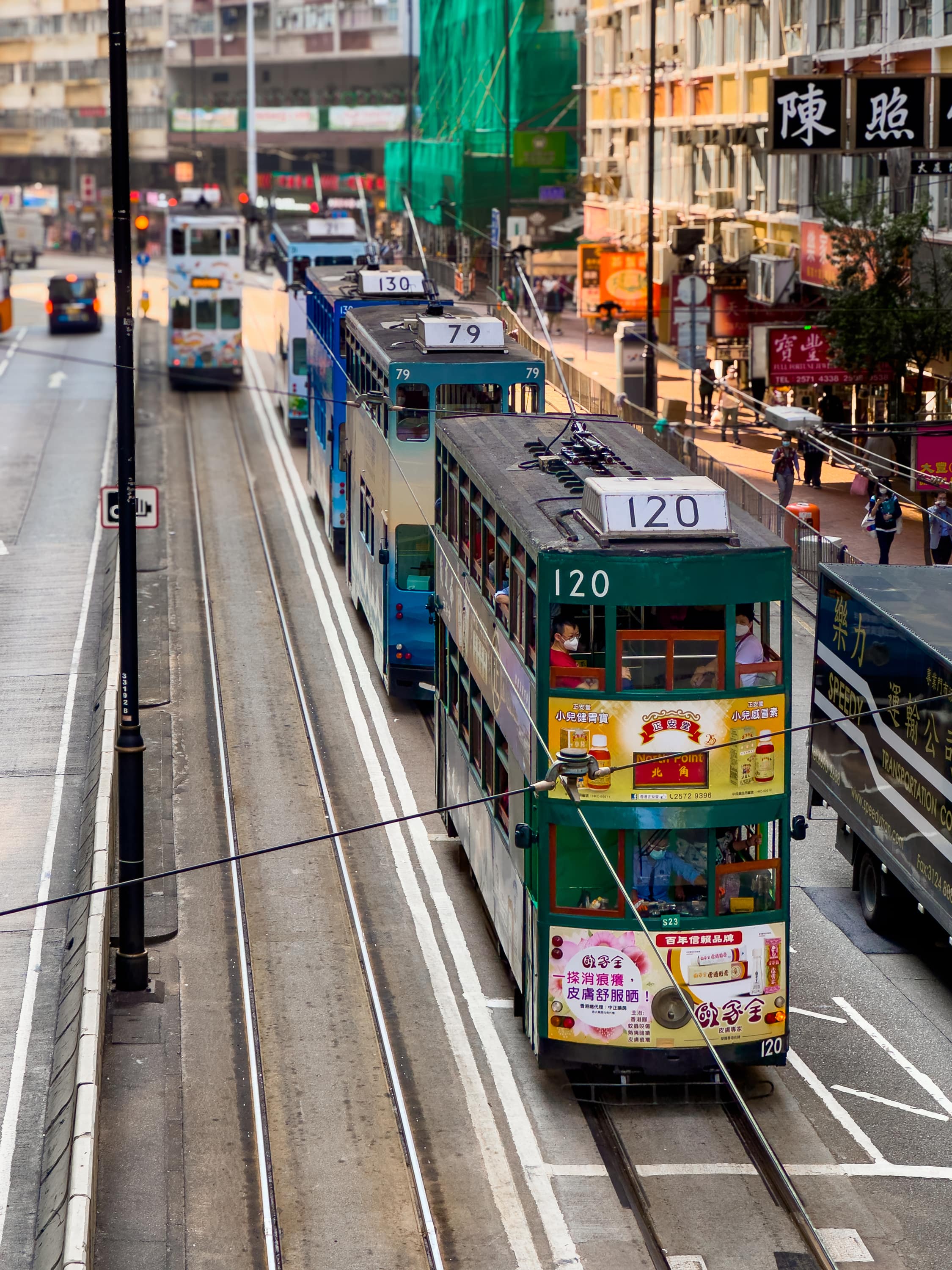 Auf einer Straße stehen mehrere Doppelstocktrams hintereinander