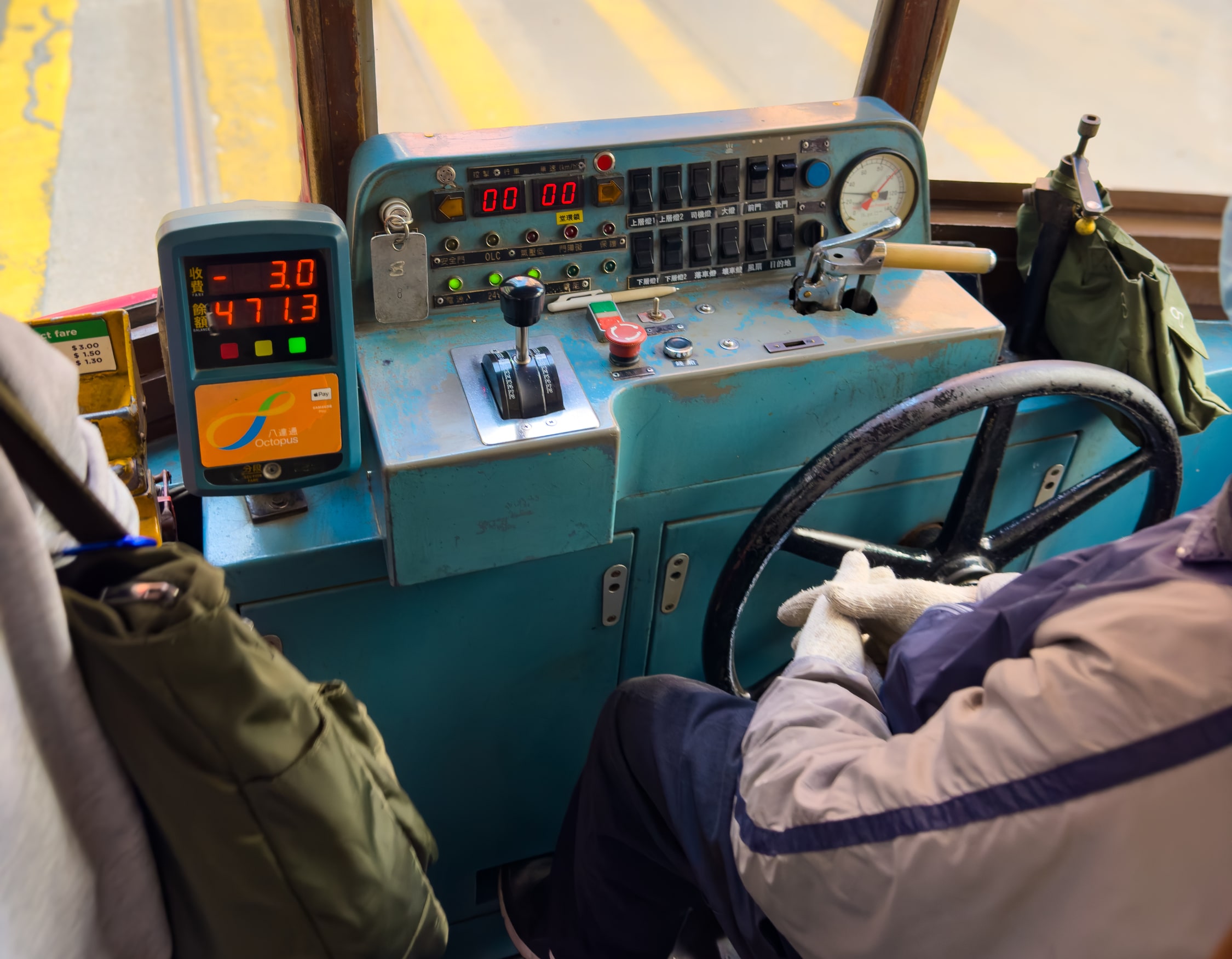 Führerstand der Straßenbahn. Links davon ein Bezahlterminal, bestehend aus einem bereich zum auflegen der NFC-Karte und zwei Zeilen 7 Segment Display, auf dem der abgebuchte Betrag von 3 HKD und der auf der Karte verbleibende Betrag angezeugt werden.