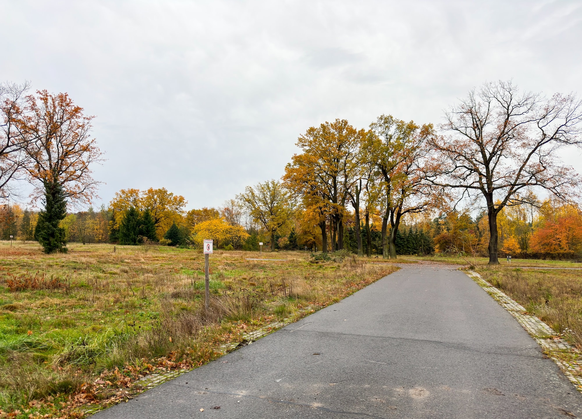 Blick entlang einer Straße. Am Rand steht ein Schild 'Privatgrundstück - Betreten Verboten'.